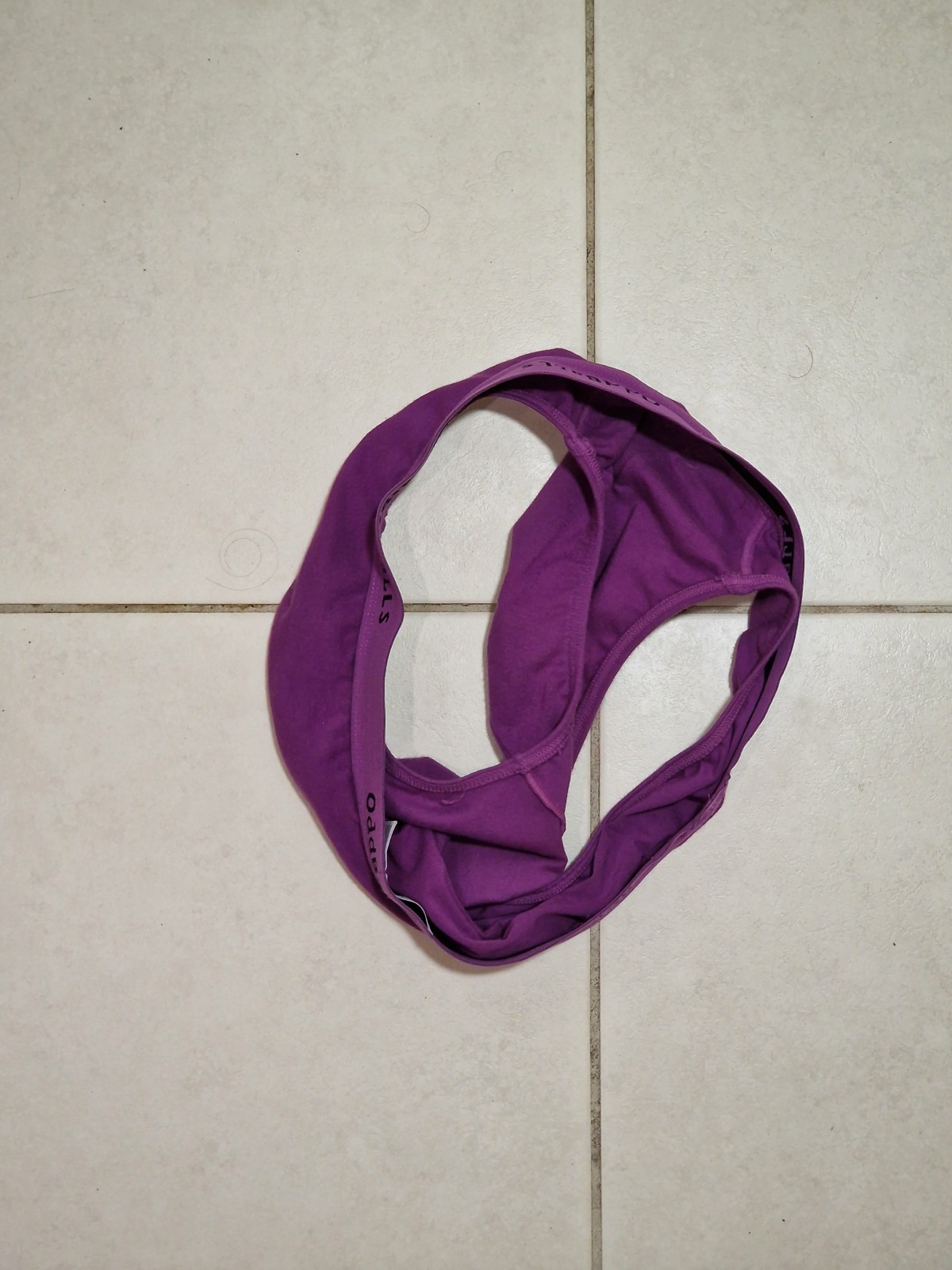 purple underwear lying on a tiled floor.