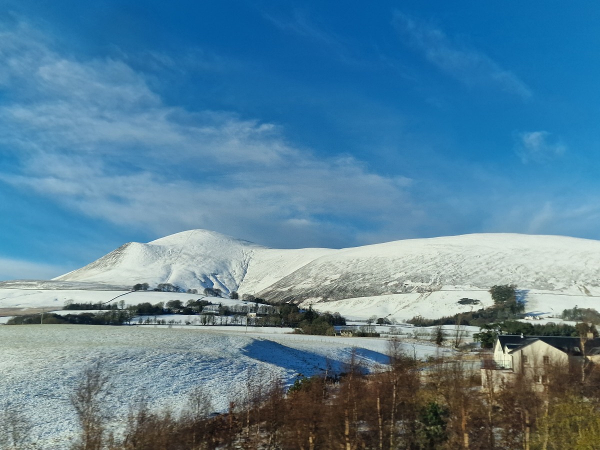 A blue sky above a snow covered hill.